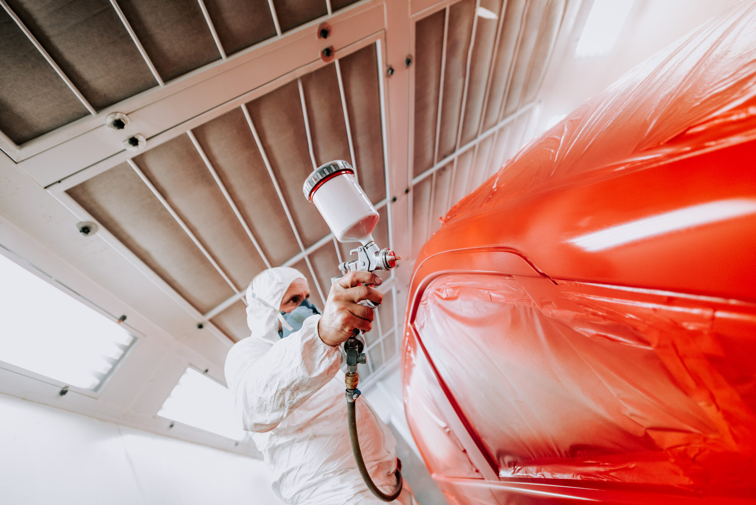 Tsco Car Paint Automotive refinishing technician painting a vehicle